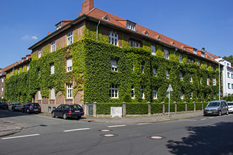 Mit Efeu bewachsene Fassade eines großen Mehrparteien-Hauses an der Melcherstraße im Kreuzviertel von Münster